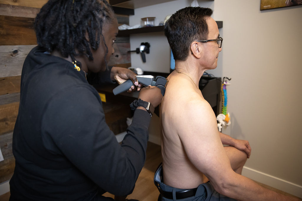 Chiropractor Treating Patient Using Tool On Back